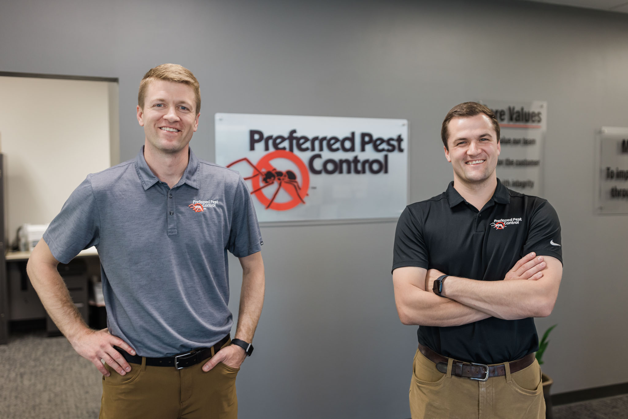 preferred pest employees in front of sign